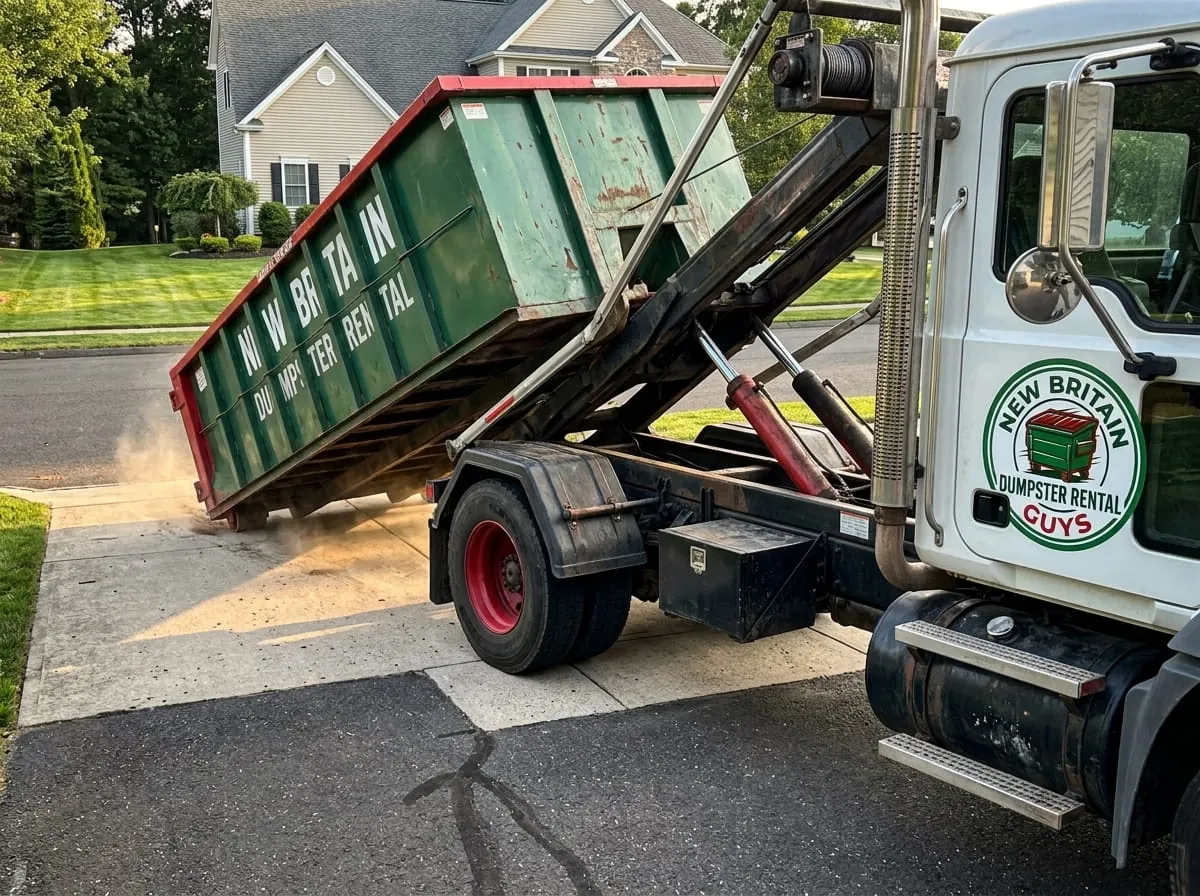 Roll-off truck tipping a container on a residential driveway in New Britain, Connecticut